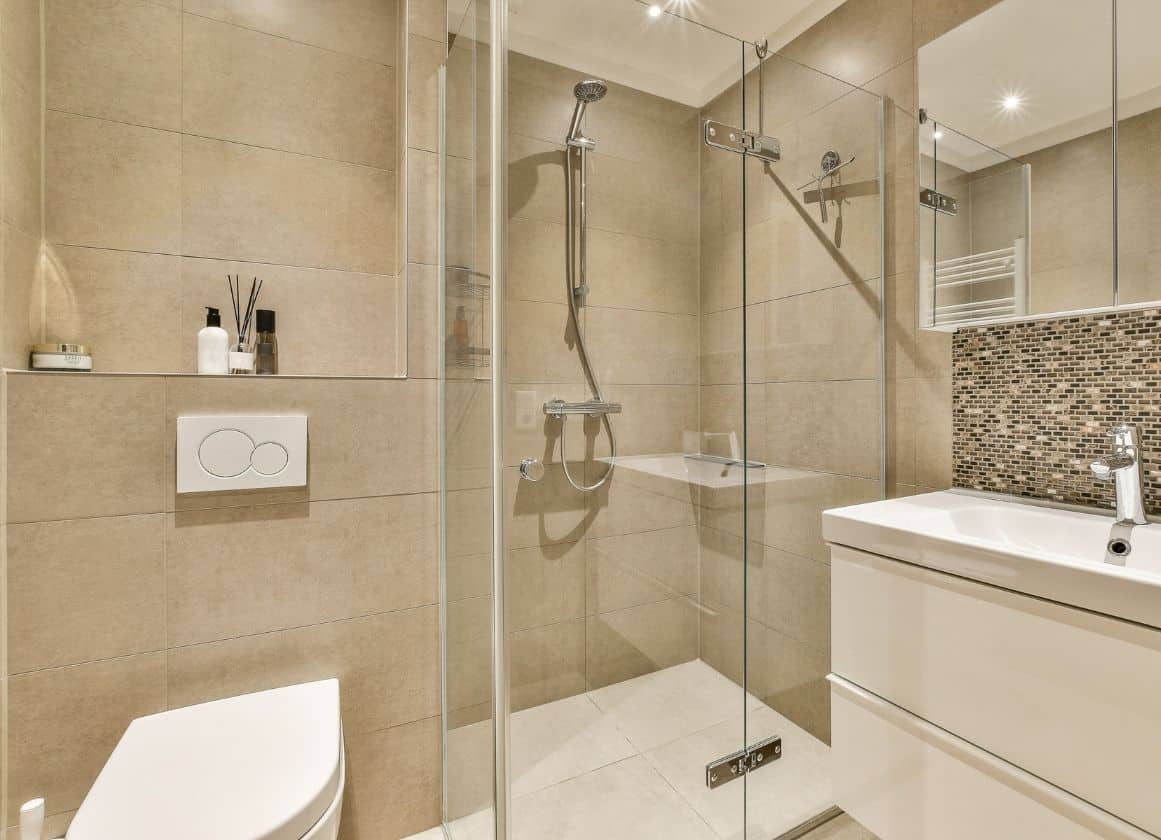 Salle de bain moderne avec douche à l’italienne, lavabo suspendu et équipements sanitaires contemporains