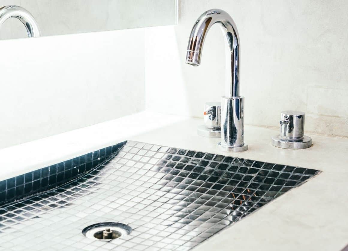 Robinetterie moderne installée sur un lavabo de salle de bain avec finitions contemporaines