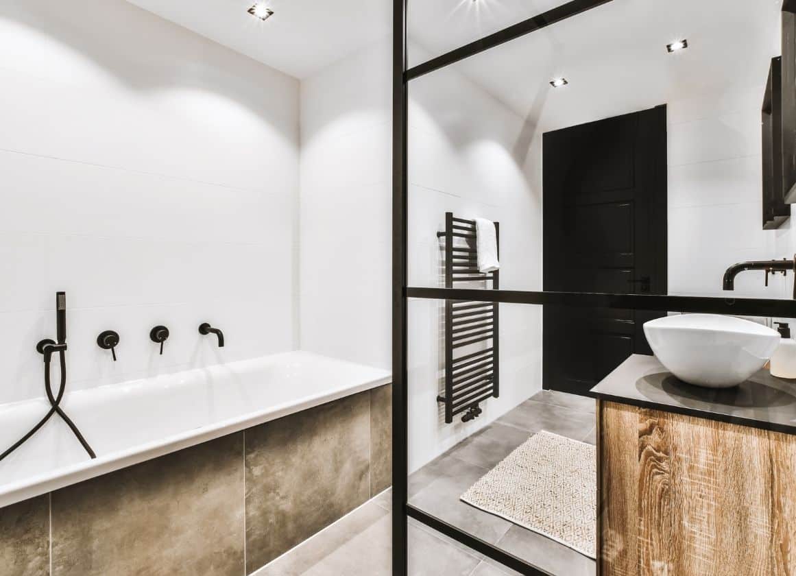Salle de bain moderne rénovée avec baignoire, meuble vasque et équipements sanitaires installés par un plombier professionnel.